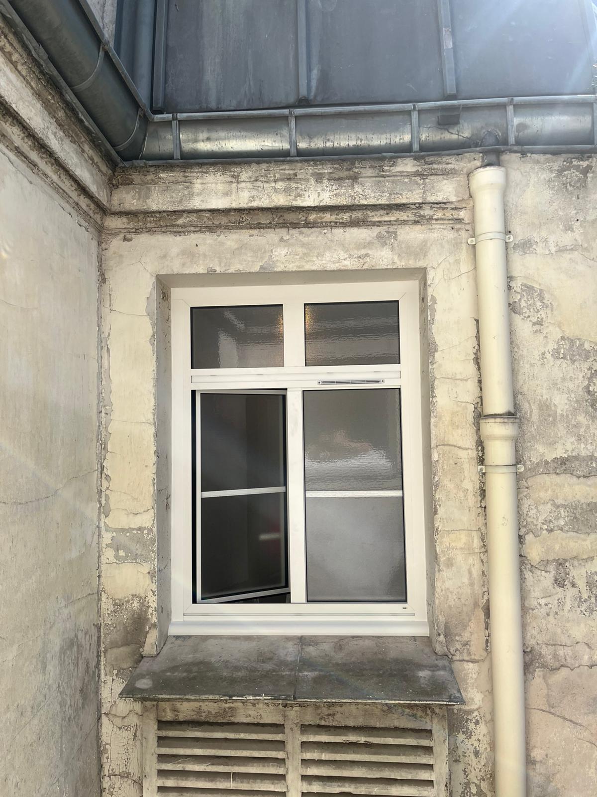 Fenêtre coulissante en aluminium noir avec grande baie vitrée offrant une vue panoramique